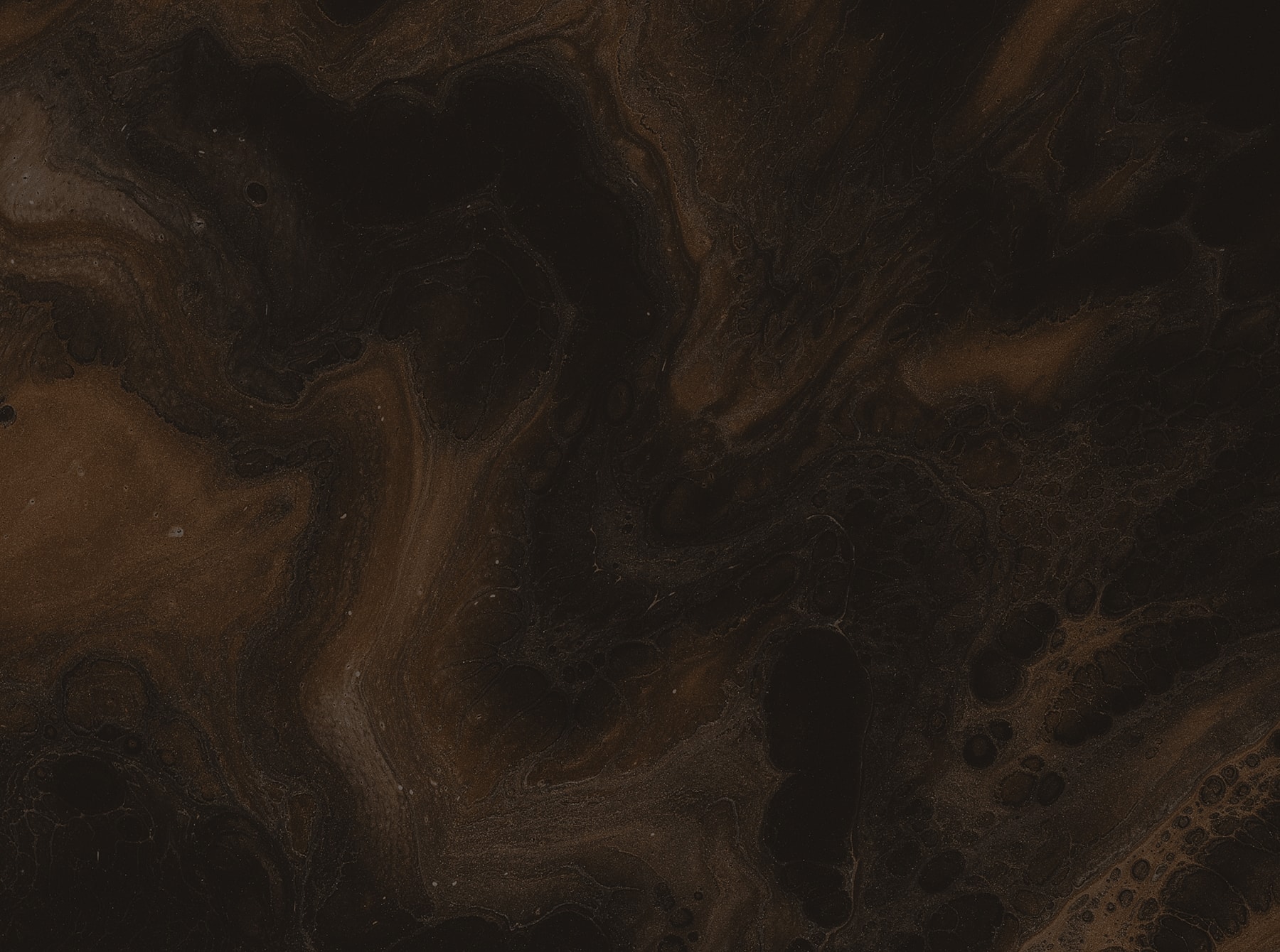 Dark abstract texture with brown swirls.