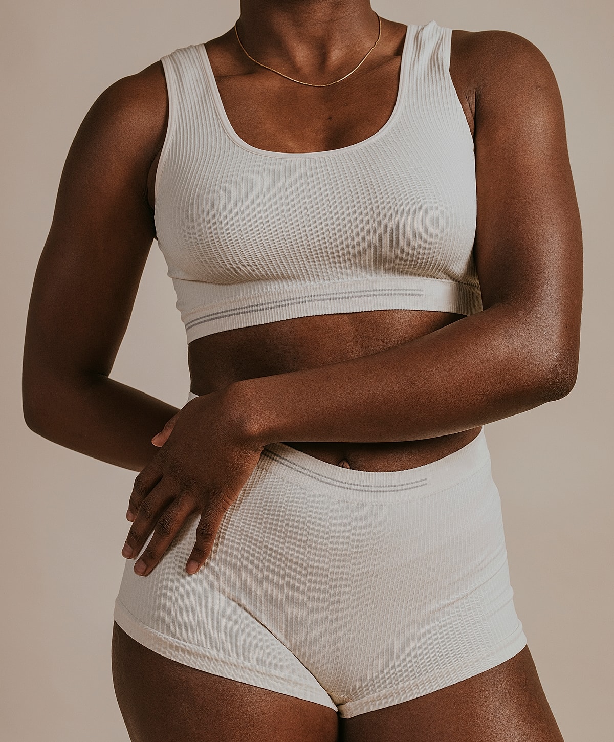 Model in light ribbed activewear top and shorts.