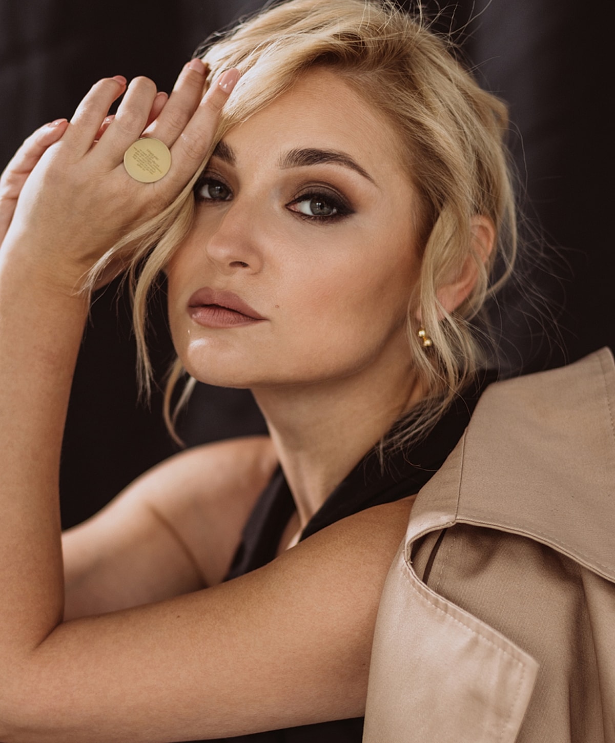 Woman posing with stylish makeup and clothing.