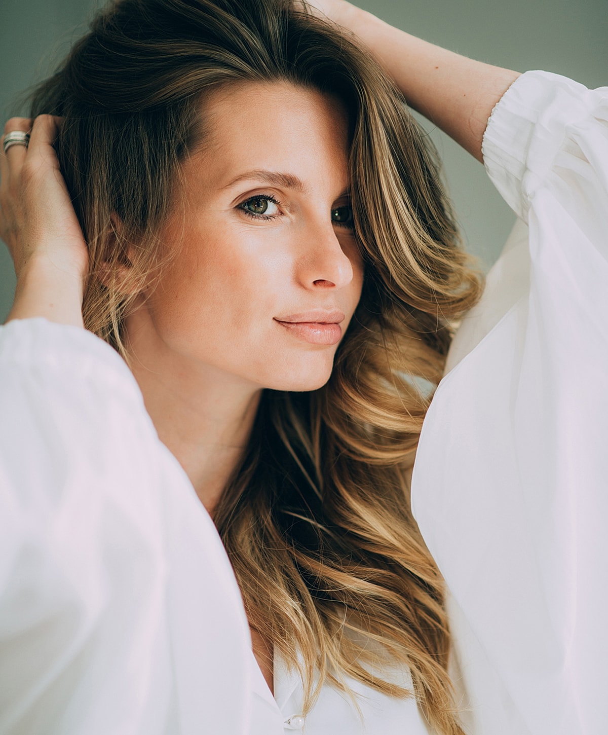 Woman with wavy hair, gazing confidently at camera.