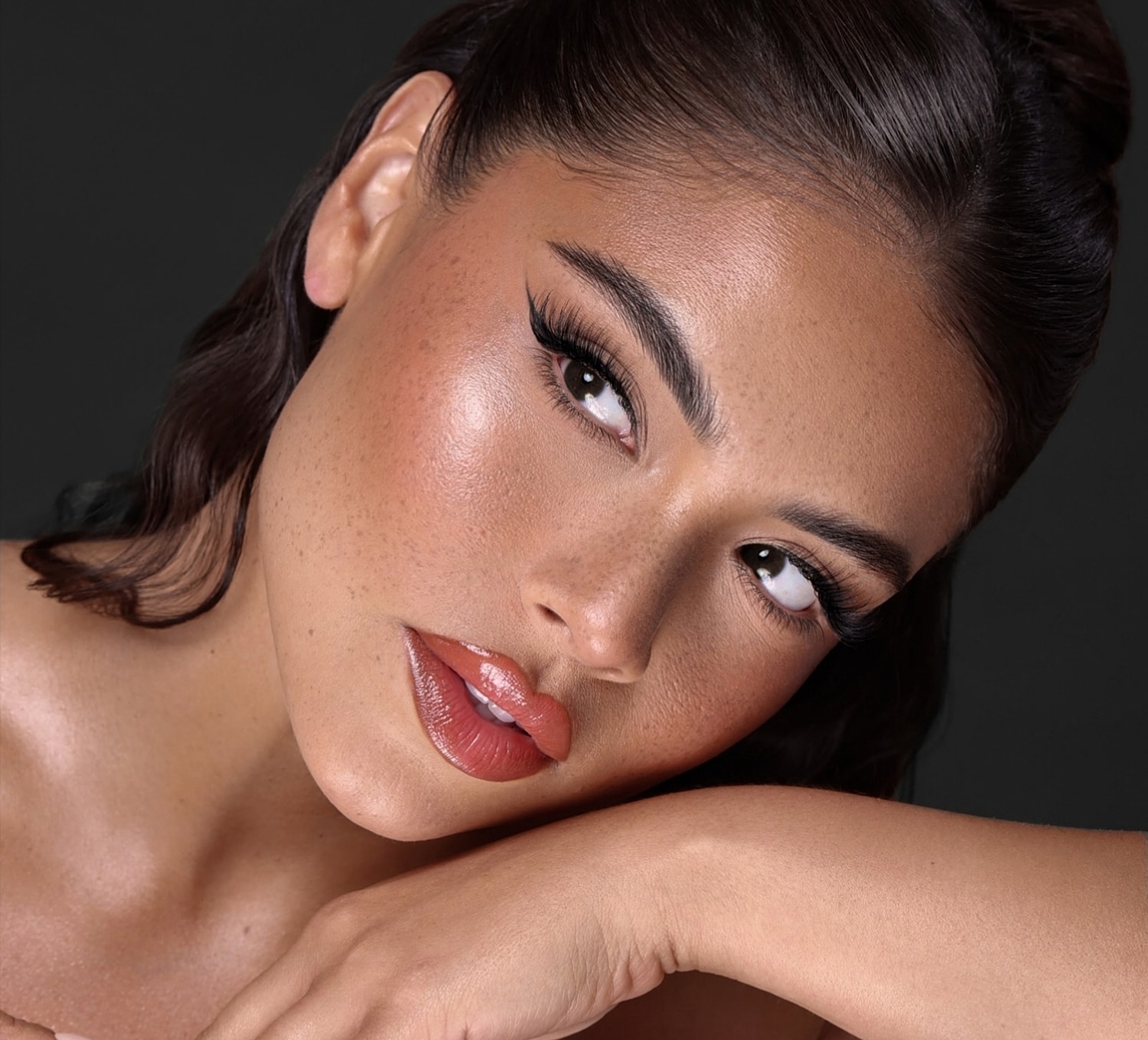 Close-up of woman with flawless makeup and expression.