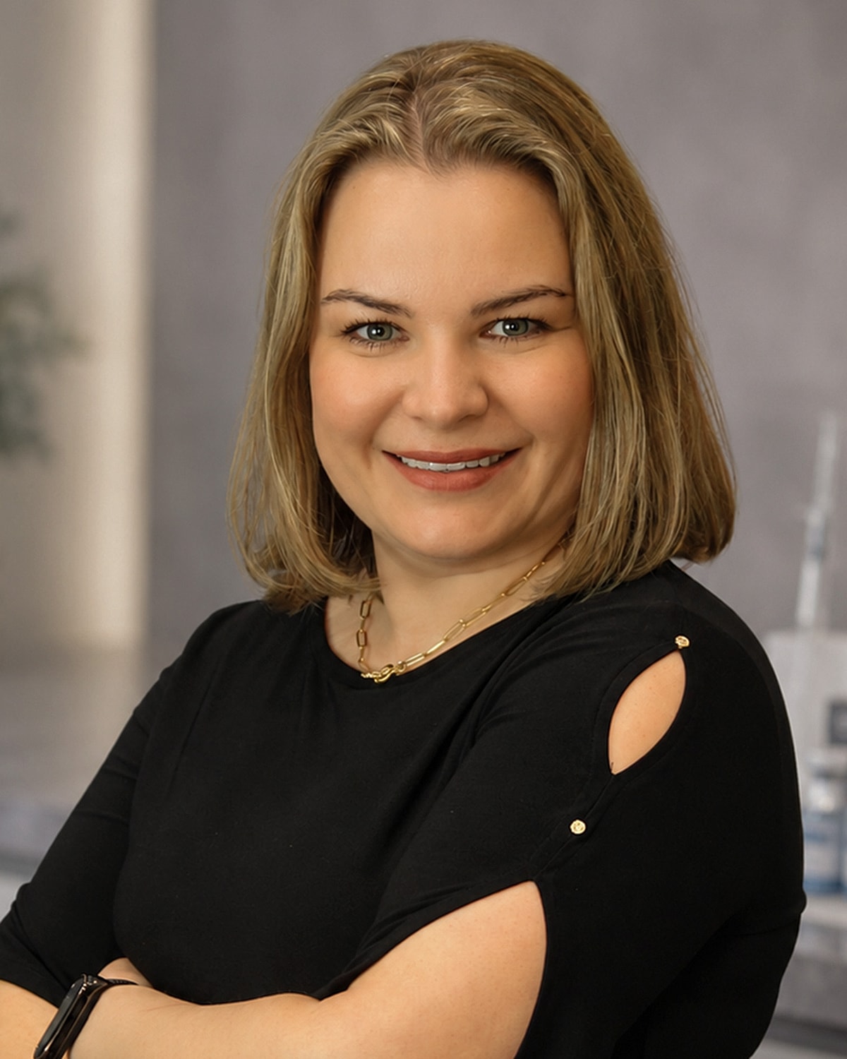 Professional woman smiling with crossed arms.