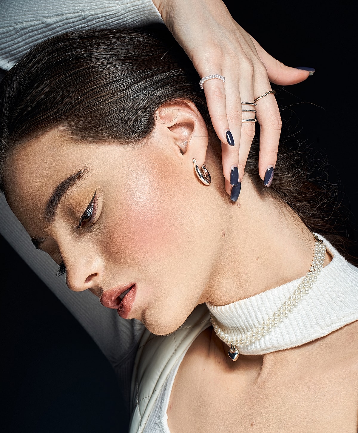 Model showcasing elegant jewelry and hairstyle.