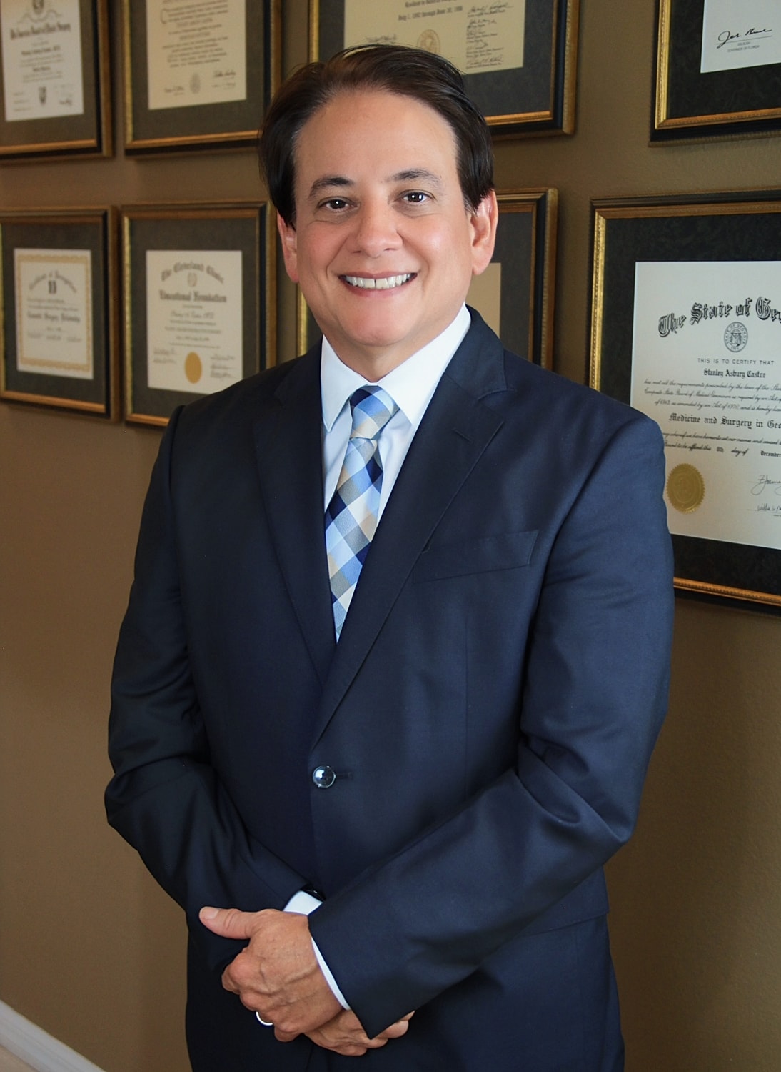 Smiling professional in a suit with certificates.