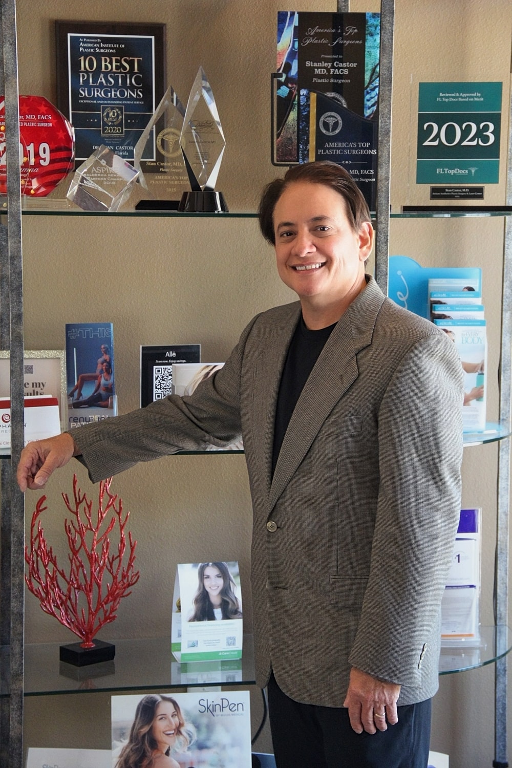 Plastic surgeon with awards and promotional materials.