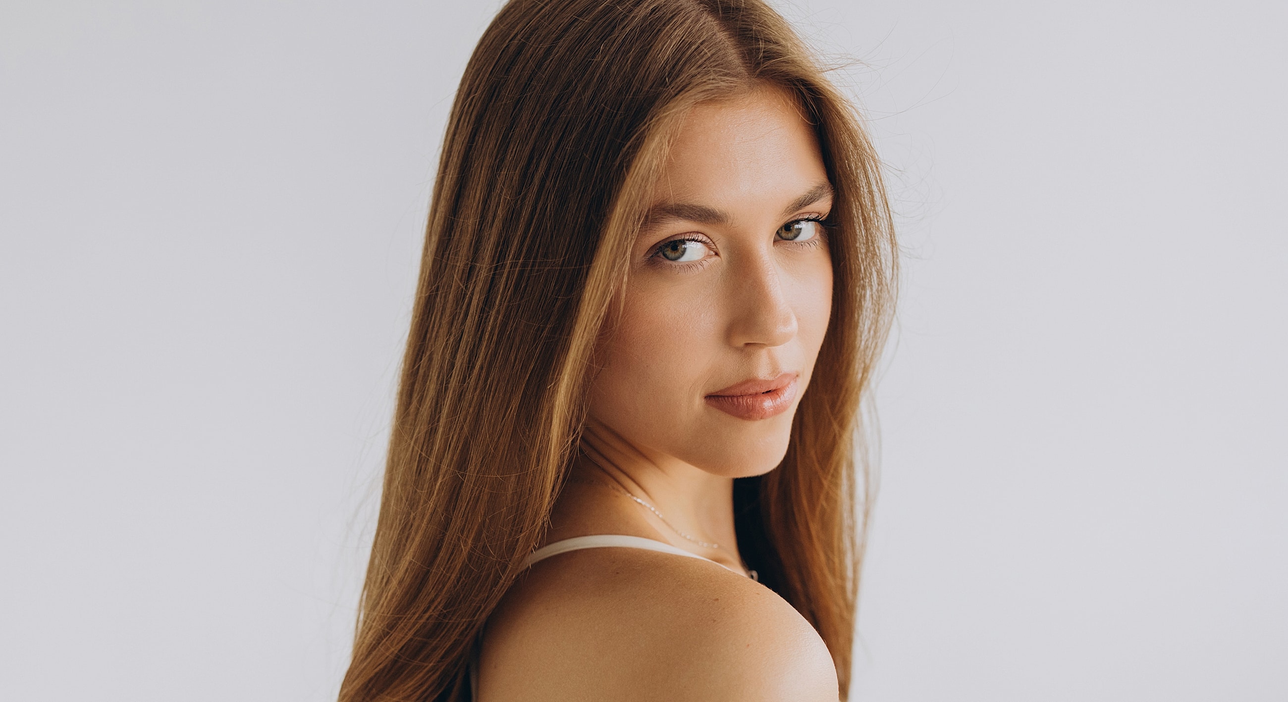 Woman with long hair posing against white background.